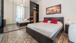 A modern bedroom with a large bed, a mirror, a nightstand, and a painting on the wall. - Cozy Flat Borgo Pio (Rome)