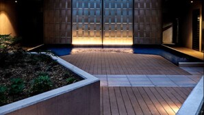 Un edificio moderno con un patio central, que cuenta con una cubierta de madera y una entrada de cristal.