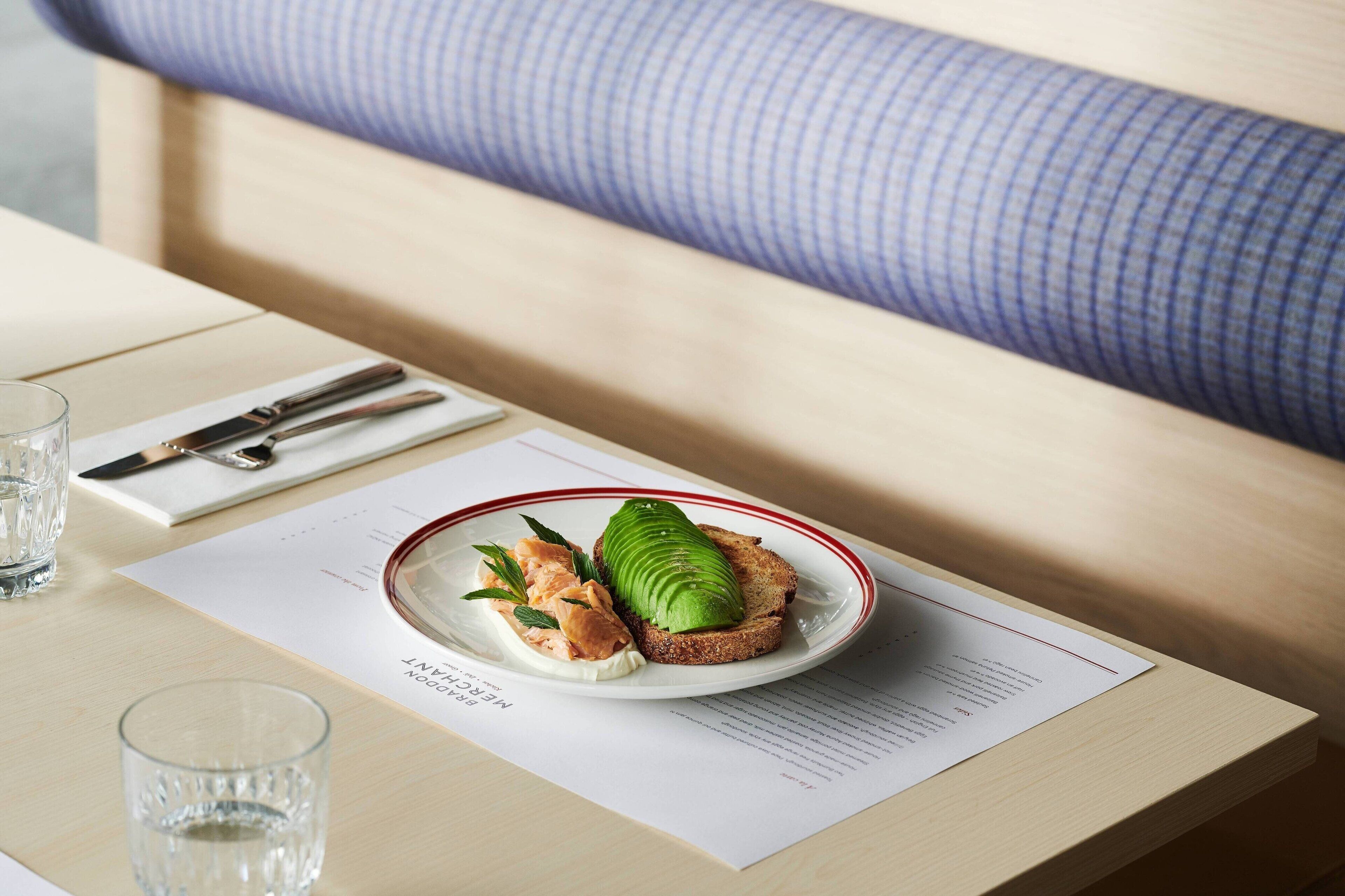 A neatly arranged breakfast table with a plate of food, a glass of water, and a menu.