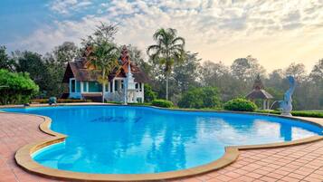 Una piscina al aire libre, sillones reclinables de piscina