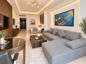 A modern living room with a grey sofa, a coffee table, and a TV. - Nordic Palace & Spa (Manama)