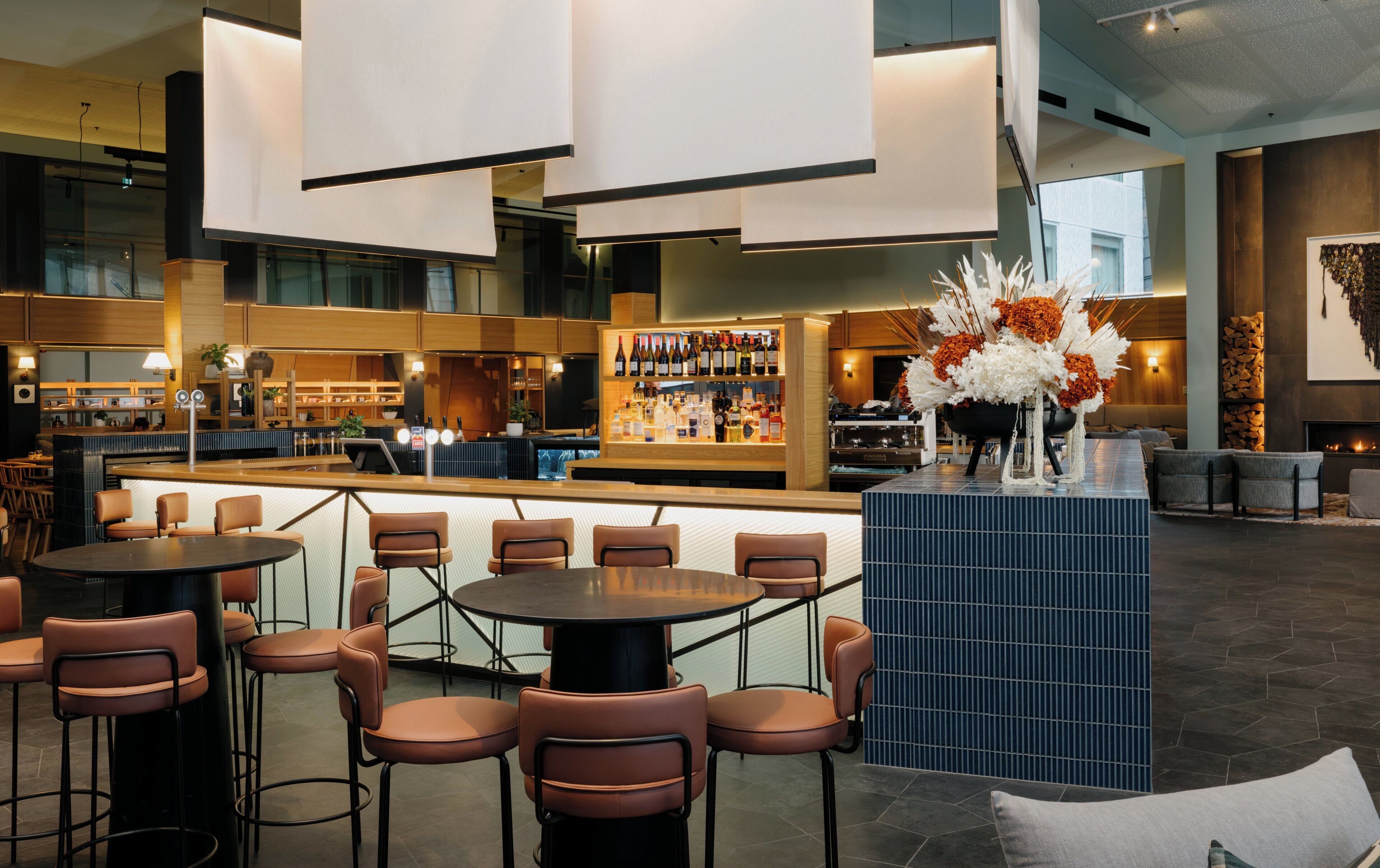 Un área de bar moderna con asientos, una barra y una decoración floral.