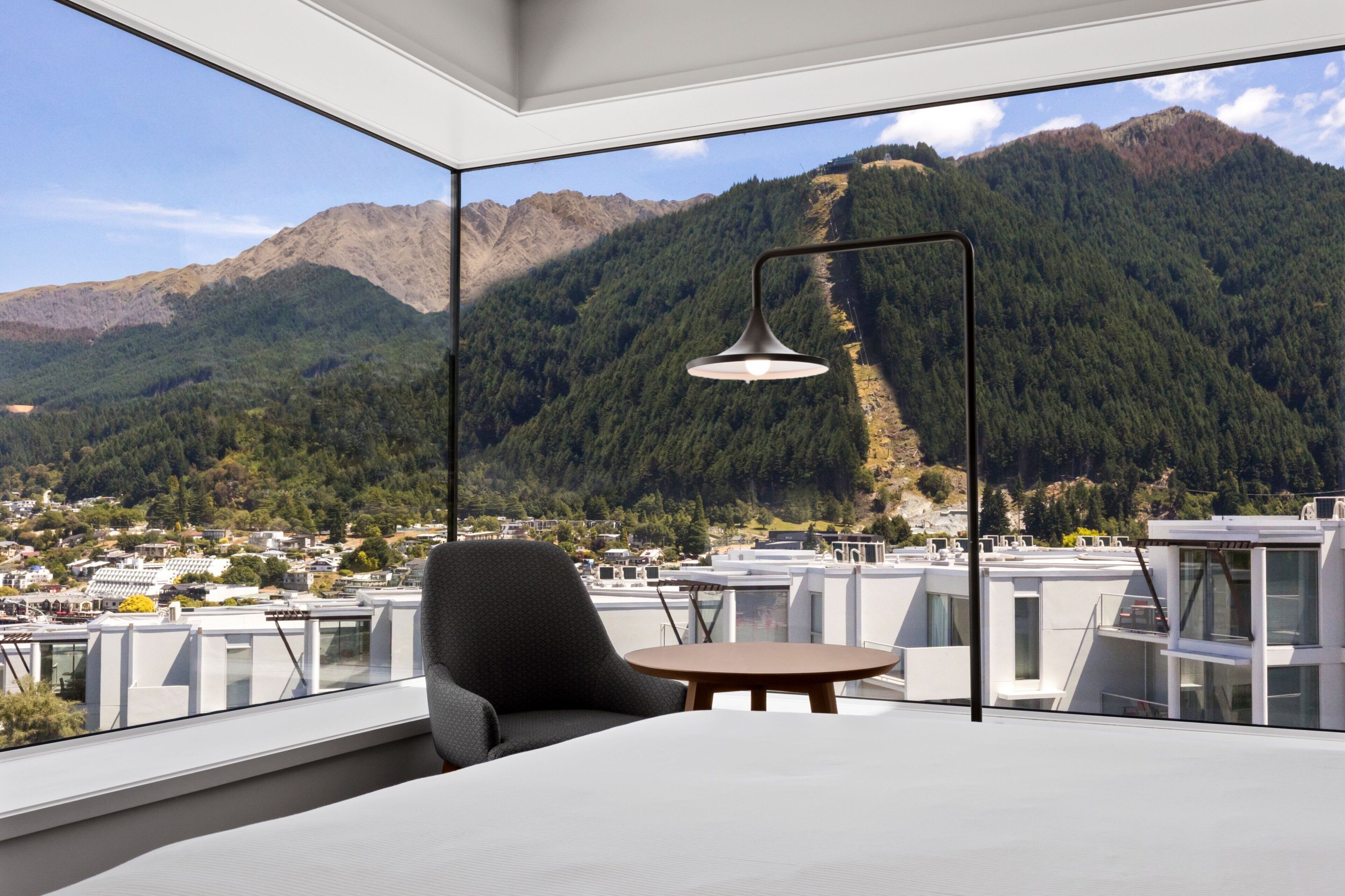 A modern room with a large window overlooking a mountainous landscape.