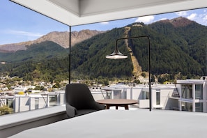 A modern room with a large window overlooking a mountainous landscape. - voco Queenstown by IHG (Queenstown)