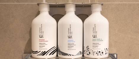 Three bottles of skincare products on a bathroom shelf.