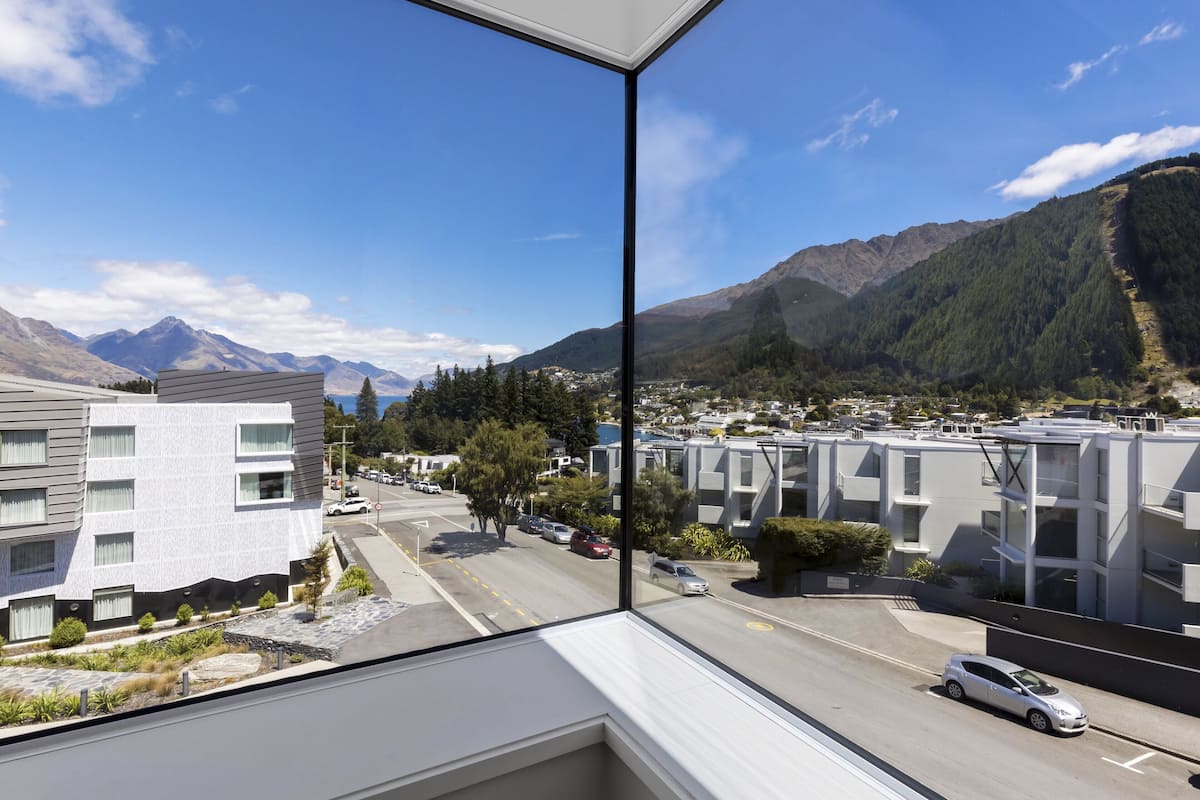 A modern building with a view of a mountain range and a town.
