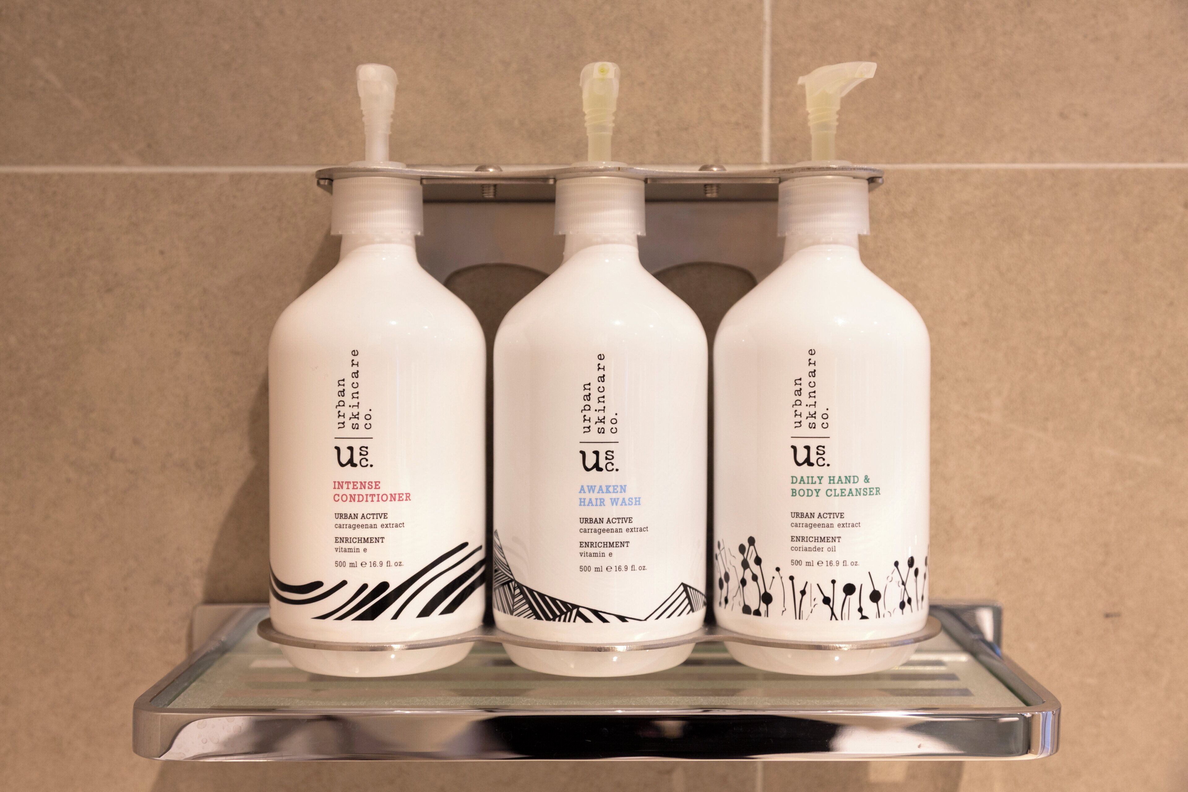 Three bottles of skincare products on a shelf.