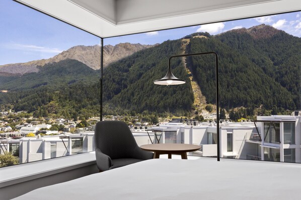 Una habitación moderna con un gran ventanal con vistas a un paisaje montañoso.
