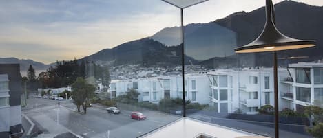 Un interior moderno con un amplio ventanal que ofrece vistas a la ciudad y a las montañas.