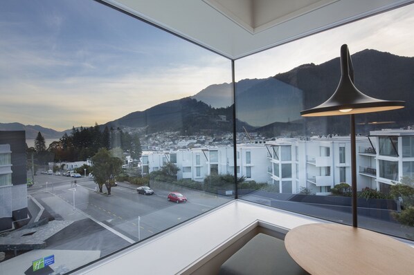 Enjoy a panoramic view of the city and surrounding mountains from this hotel room's large window.
