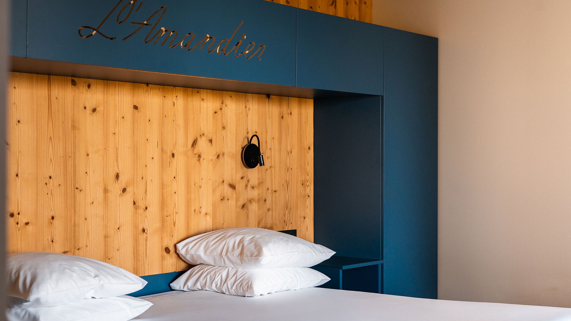 A bedroom with a wooden headboard, a bedside table, and a bed with white bedding.