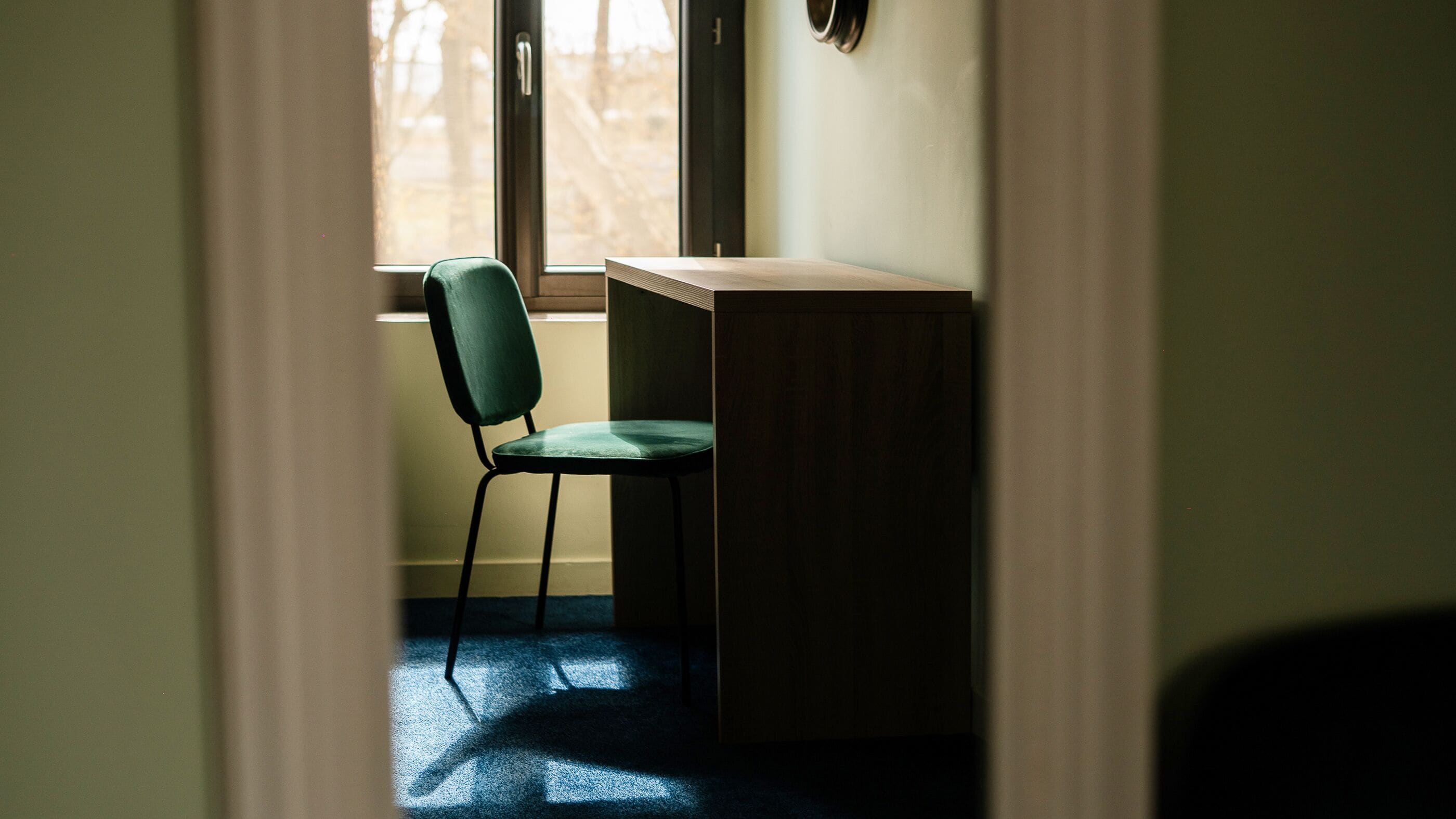 A room with a desk, a chair, and a window.