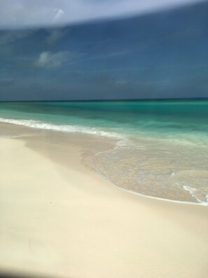 A beach with clear turquoise water and a sandy shore.