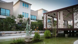 Un edificio moderno con amplios ventanales y un área exterior cubierta con barandilla decorativa.