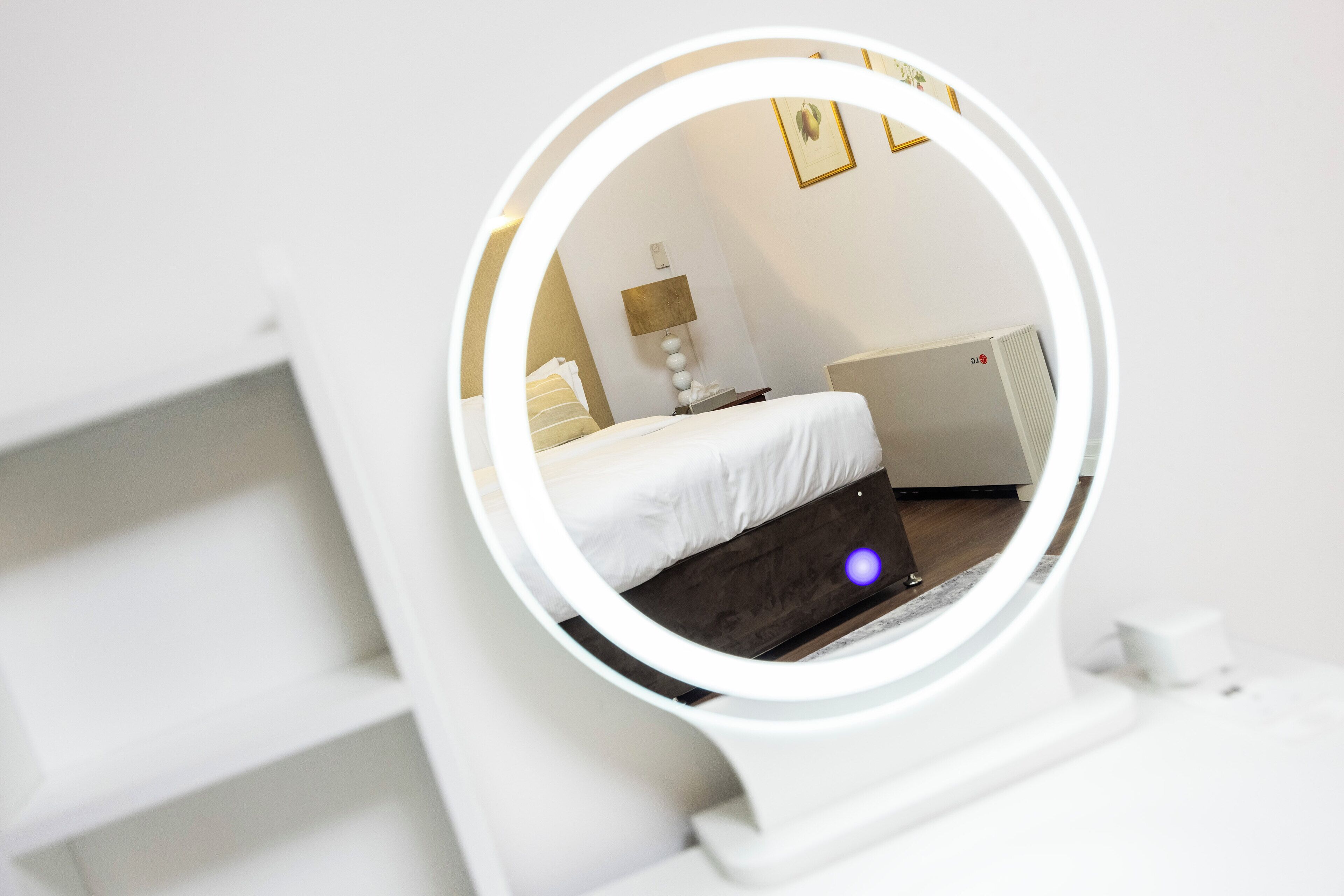 A modern bedroom with a bed, a bedside table, a lamp, and a wall-mounted radiator.
