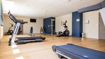 A gym with treadmills, stationary bikes, and exercise equipment.