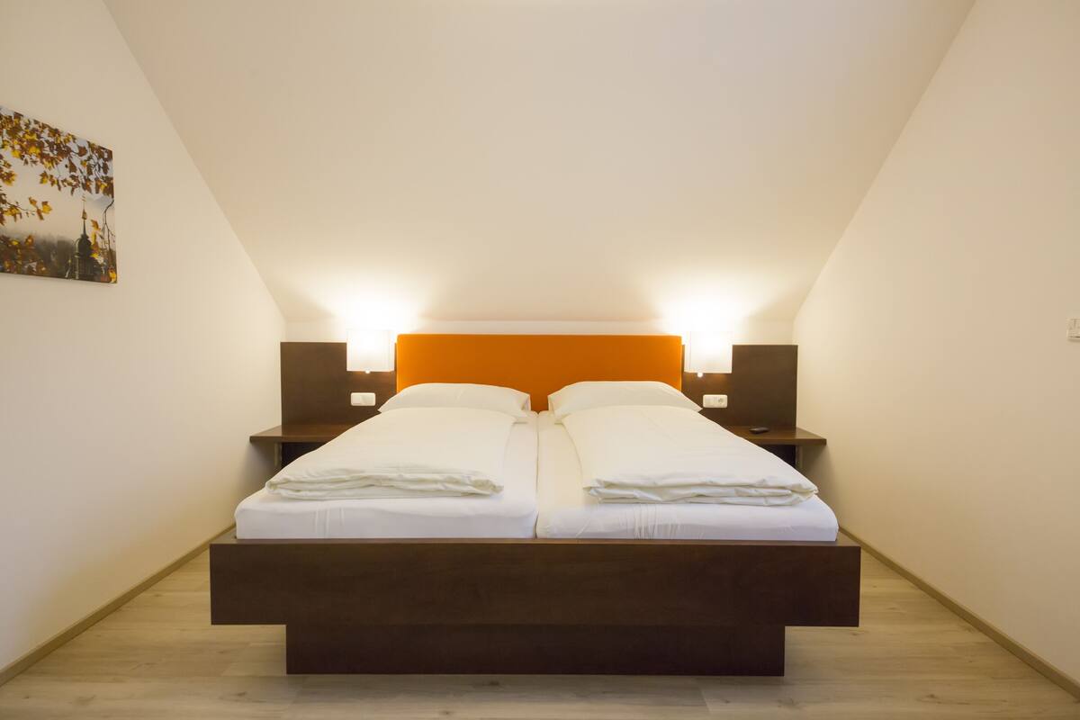 Una habitación con una cama, dos mesitas de noche y un cuadro en la pared.