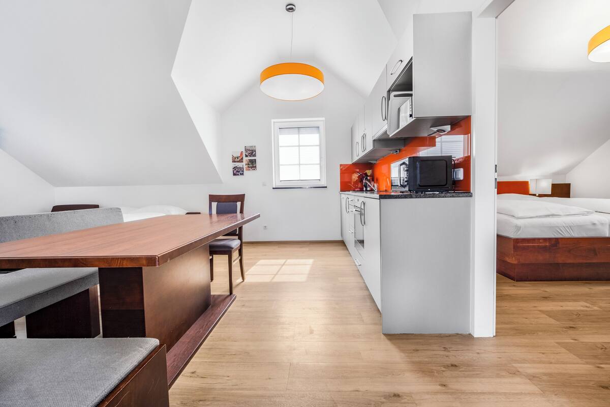 Una habitación moderna estilo loft con comedor, kitchenette y zona de descanso.