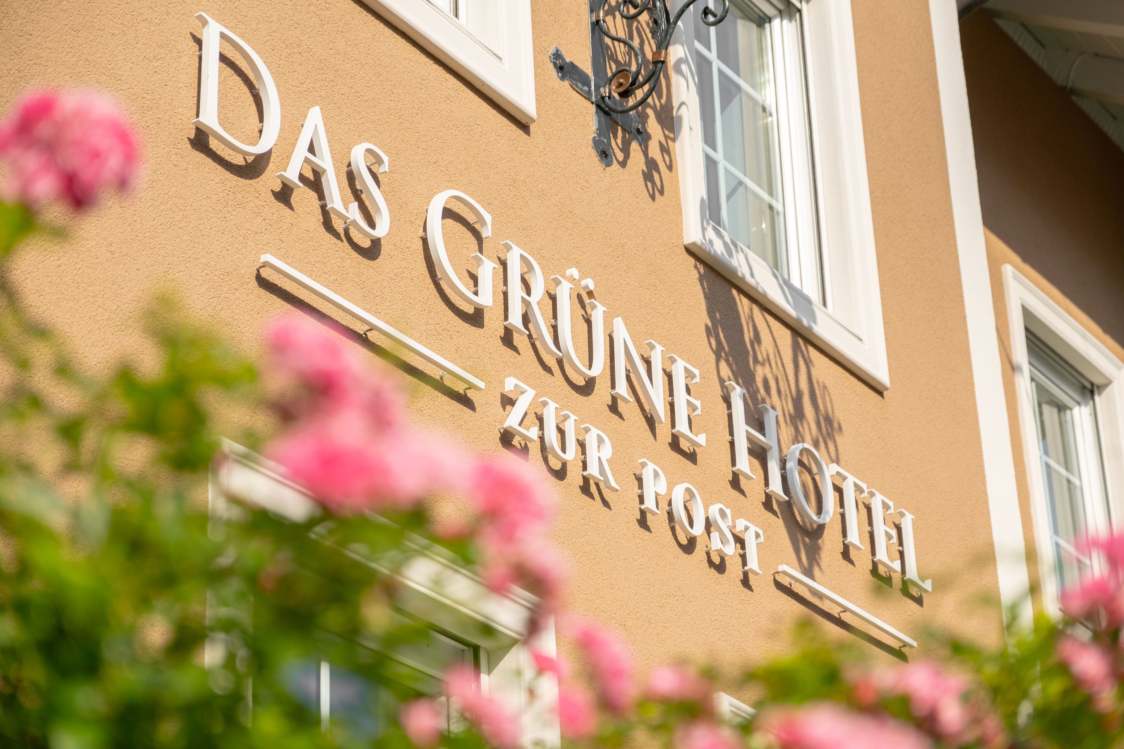 Un cartel de hotel con el nombre 'Das Grüne Hotel Zur Post'.