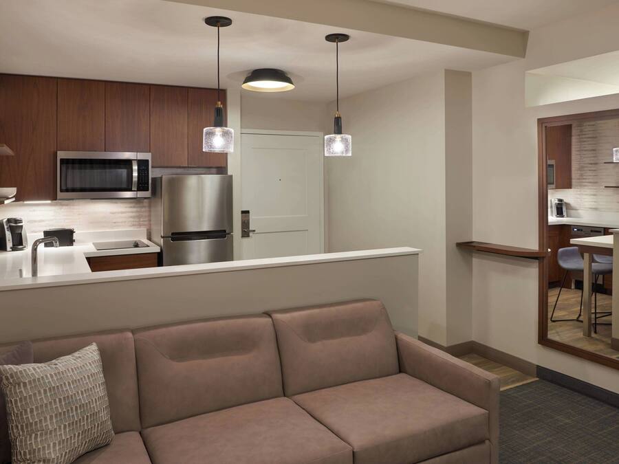 Una cocina moderna con microondas, refrigerador y luces colgantes.