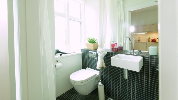 Un baño moderno con inodoro, lavabo y ventana.