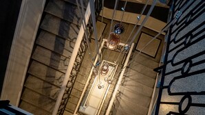 A staircase with a handrail and a metal railing on the side. - Merci Boutique Hotel (Kraków)