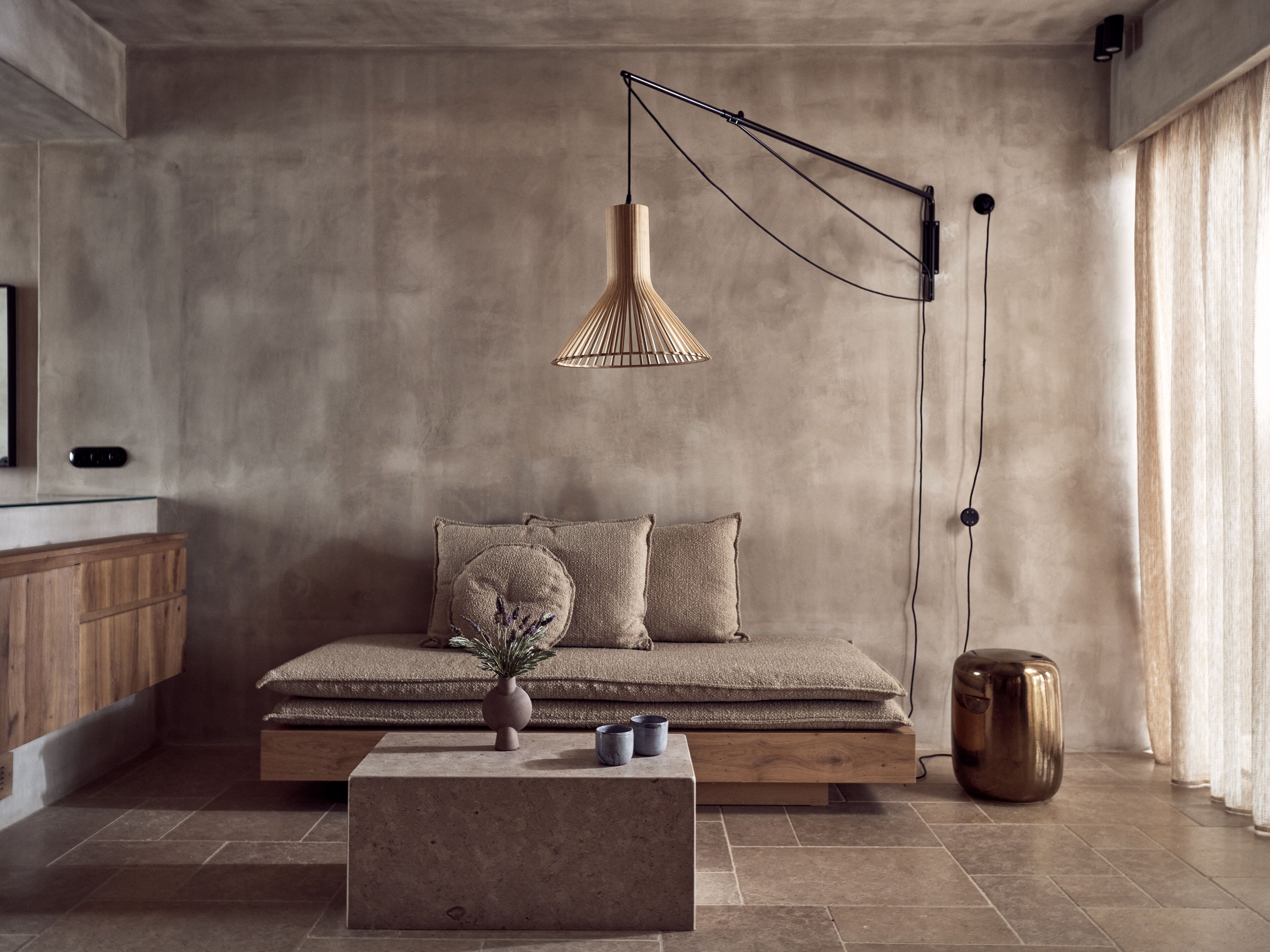 Una sala de estar moderna con diseño minimalista, que incluye un sofá, una mesa de centro y una lámpara colgante.