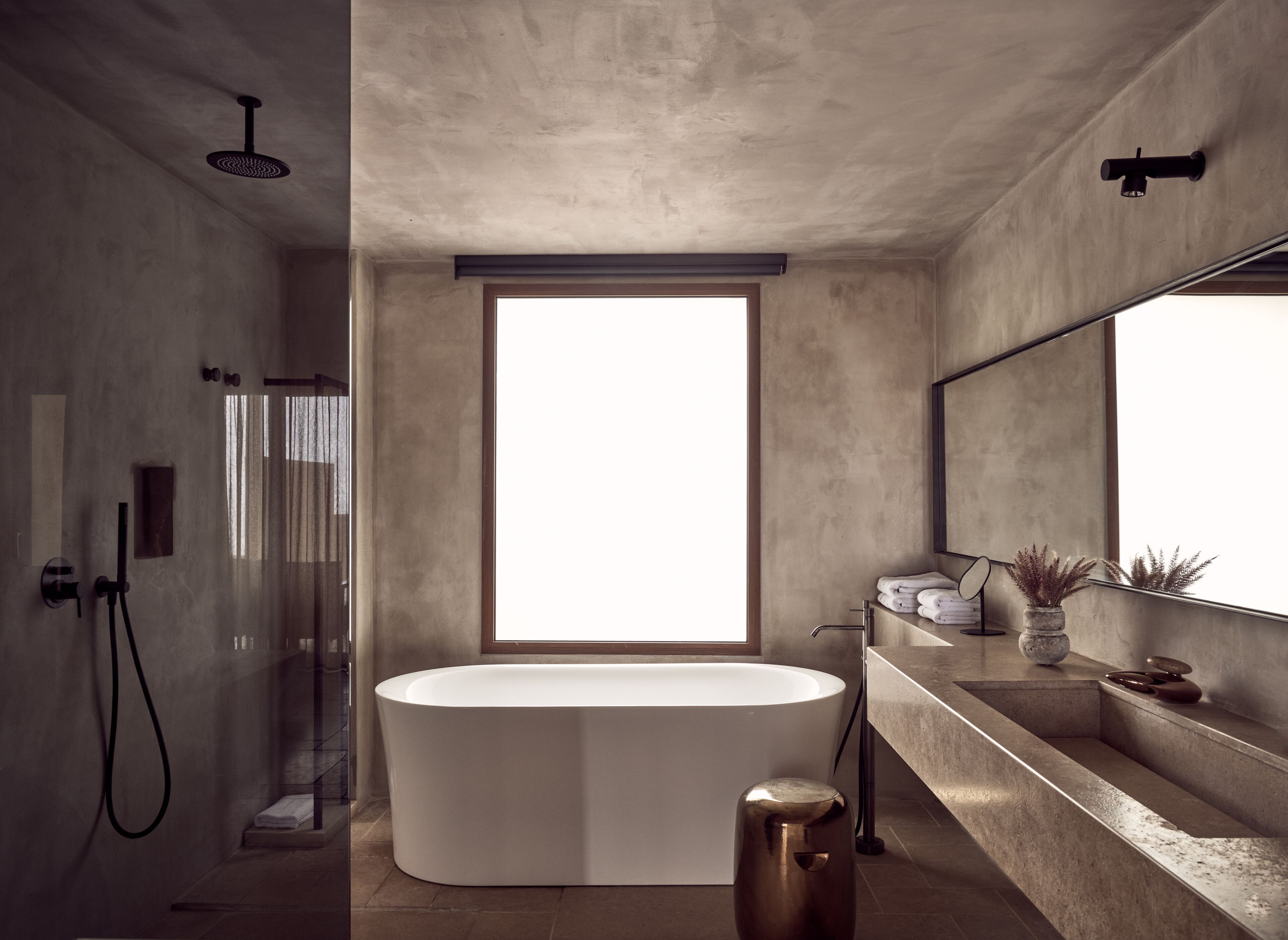 A modern bathroom with a freestanding bathtub, a large window, and a minimalist design.