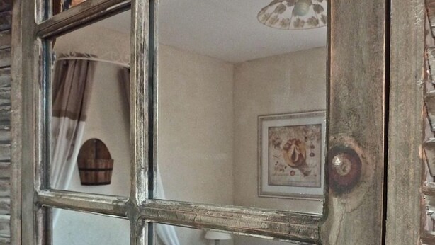 A bedroom with a bed, a nightstand, a lamp, and a framed picture on the wall.