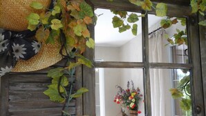 A rustic room with a wooden door, a woven basket, and a hanging plant.
