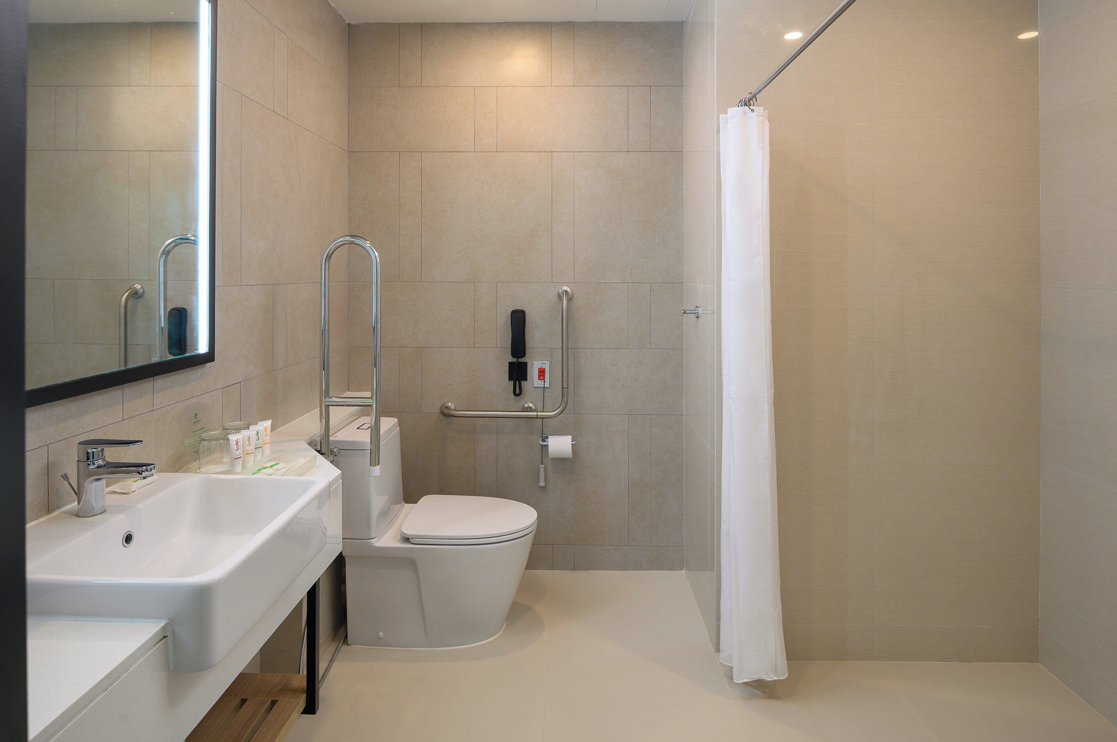 A modern bathroom with a sink, toilet, and shower.