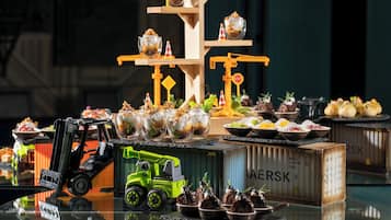 Una exhibición de postres con una carretilla elevadora y contenedores de envío.