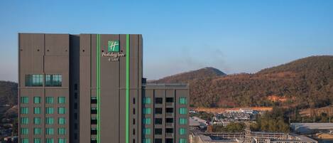 Un hotel Holiday Inn & Suites con un diseño moderno, que cuenta con varios pisos y un logotipo destacado.
