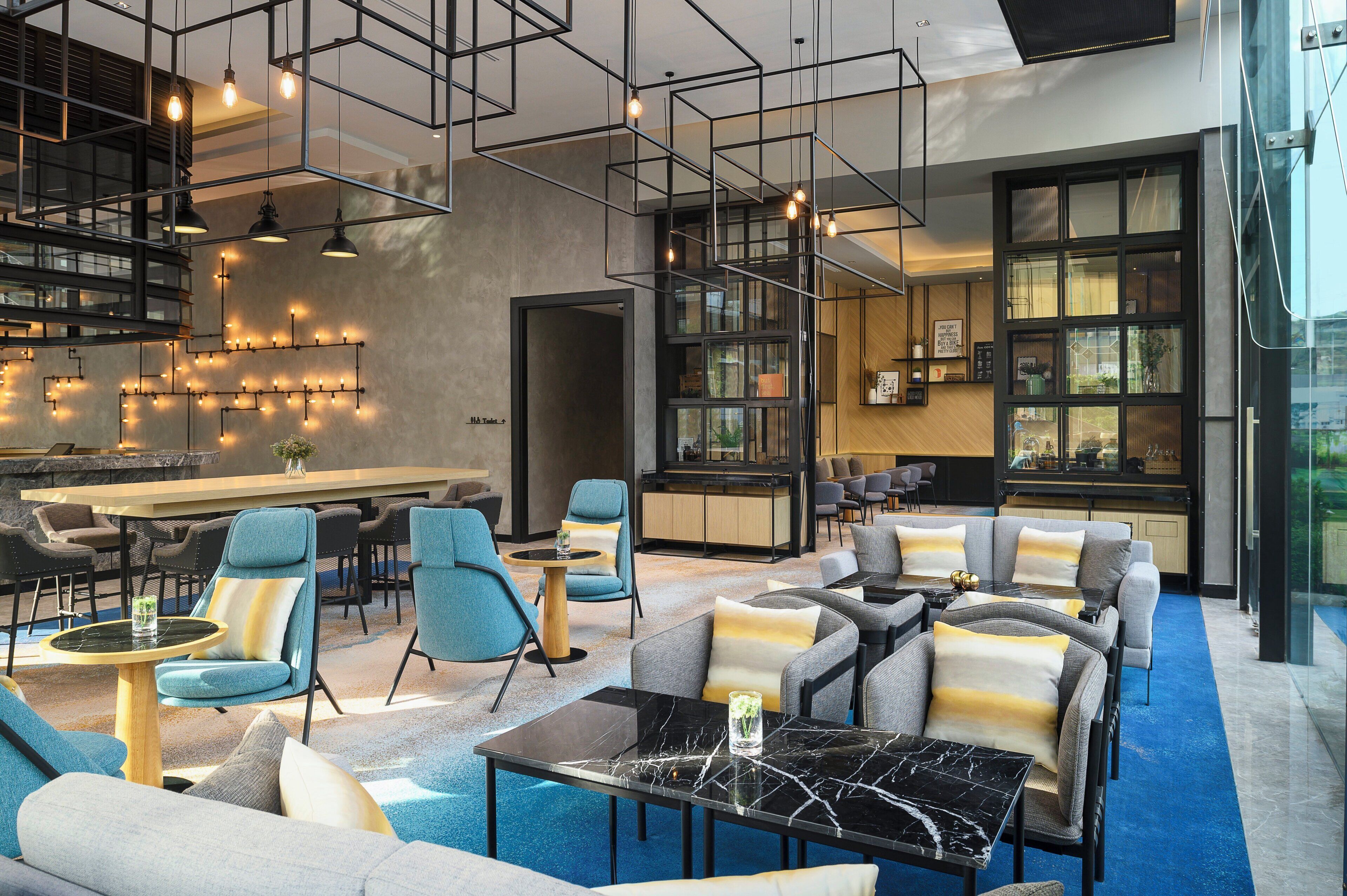 A modern lounge area with seating, a bar, and a view of the outdoors.