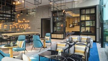 A modern lounge area with seating, a bar, and a view of the outdoors.