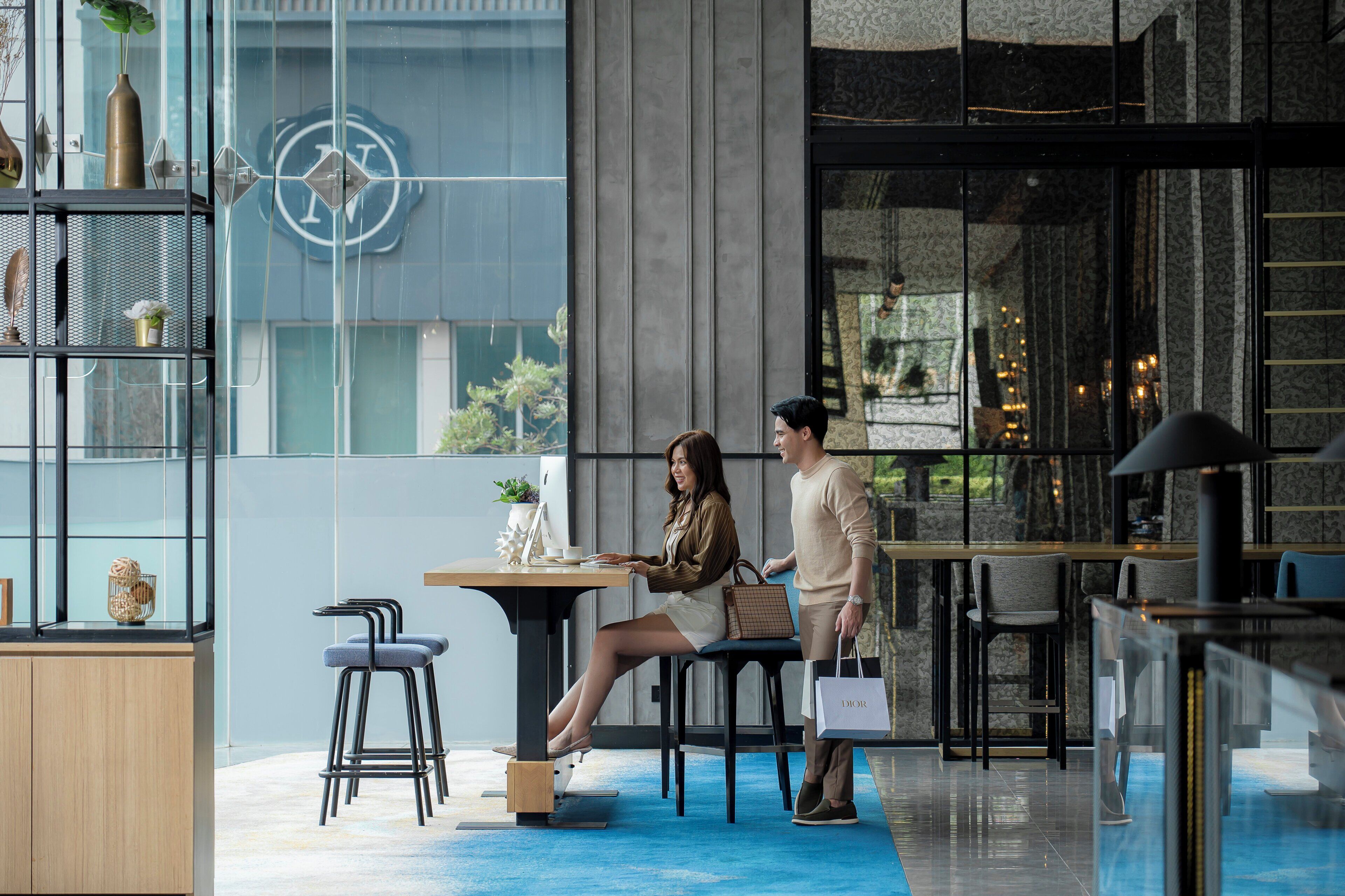 Um interior moderno com área de bar, assentos e uma grande janela com um detalhe decorativo na parede.
