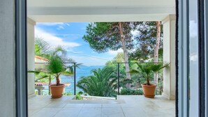 Un balcon agrémenté de plantes en pot et offrant une vue sur la mer.