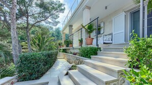 Un bâtiment doté d’un escalier en pierre menant à un balcon orné de plantes en pot.