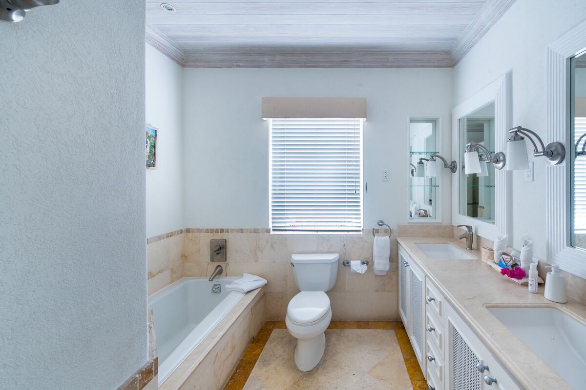 A bathroom with a bathtub, toilet, sink, and vanity.
