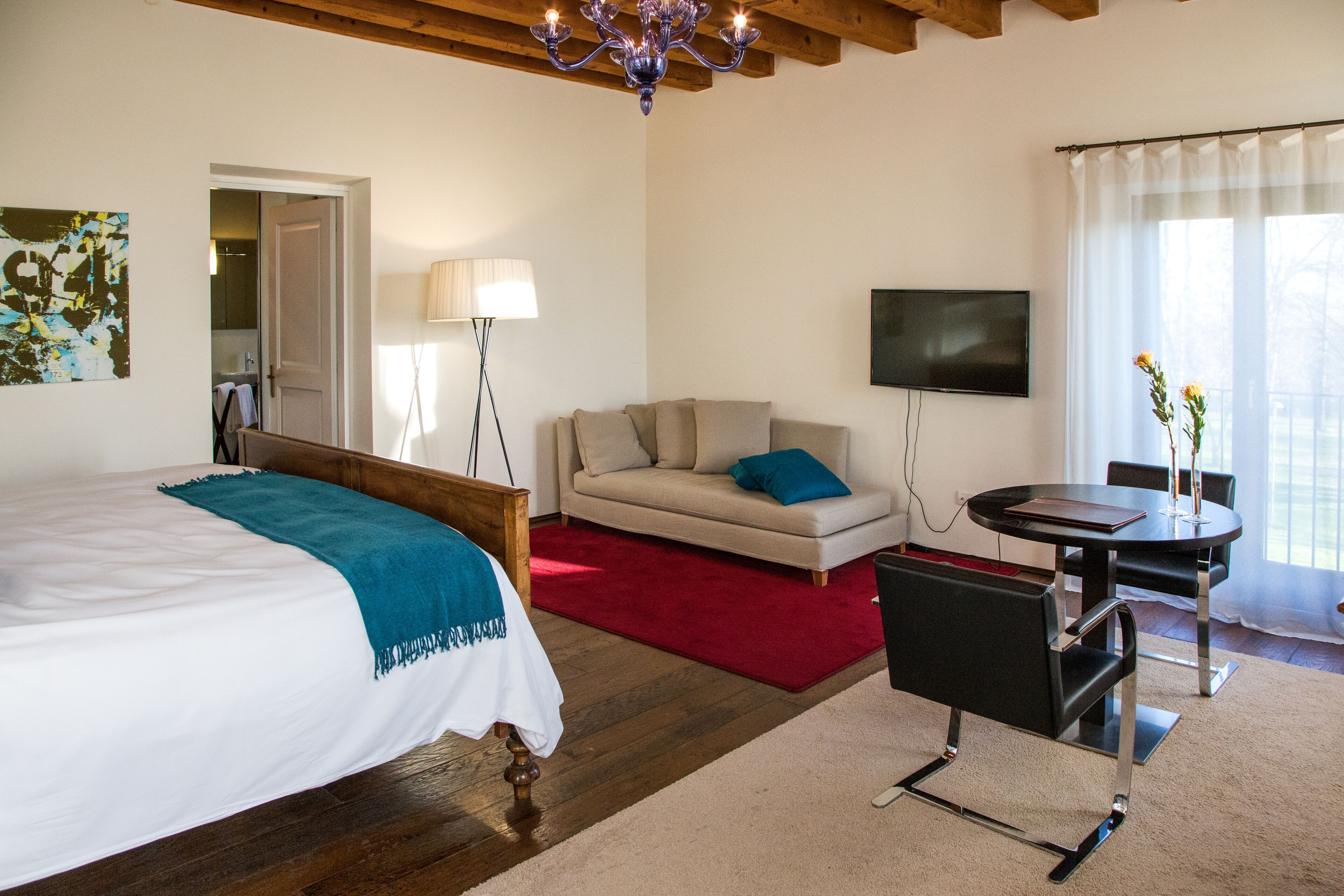 Une chambre d’hôtel comprenant un lit, un canapé, une table à manger et un téléviseur.