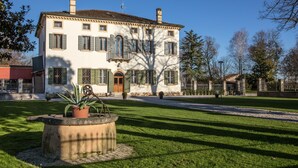 A large, two-story building with a symmetrical facade, a central entrance with a door, and a small balcony. - Relais Villa Ormaneto (Cerea)