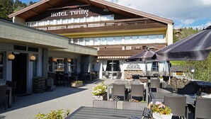 A hotel with outdoor seating and a sign reading "Hotel Twing". - Hotel Twing (Hasliberg)