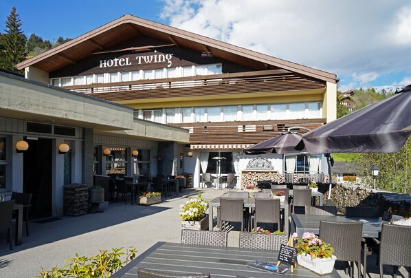 A hotel with outdoor seating and a sign reading "Hotel Twing". - Hotel Twing (Hasliberg)