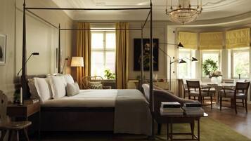 Una cama con dosel y cuatro columnas, un comedor con mesa y sillas, y una araña.