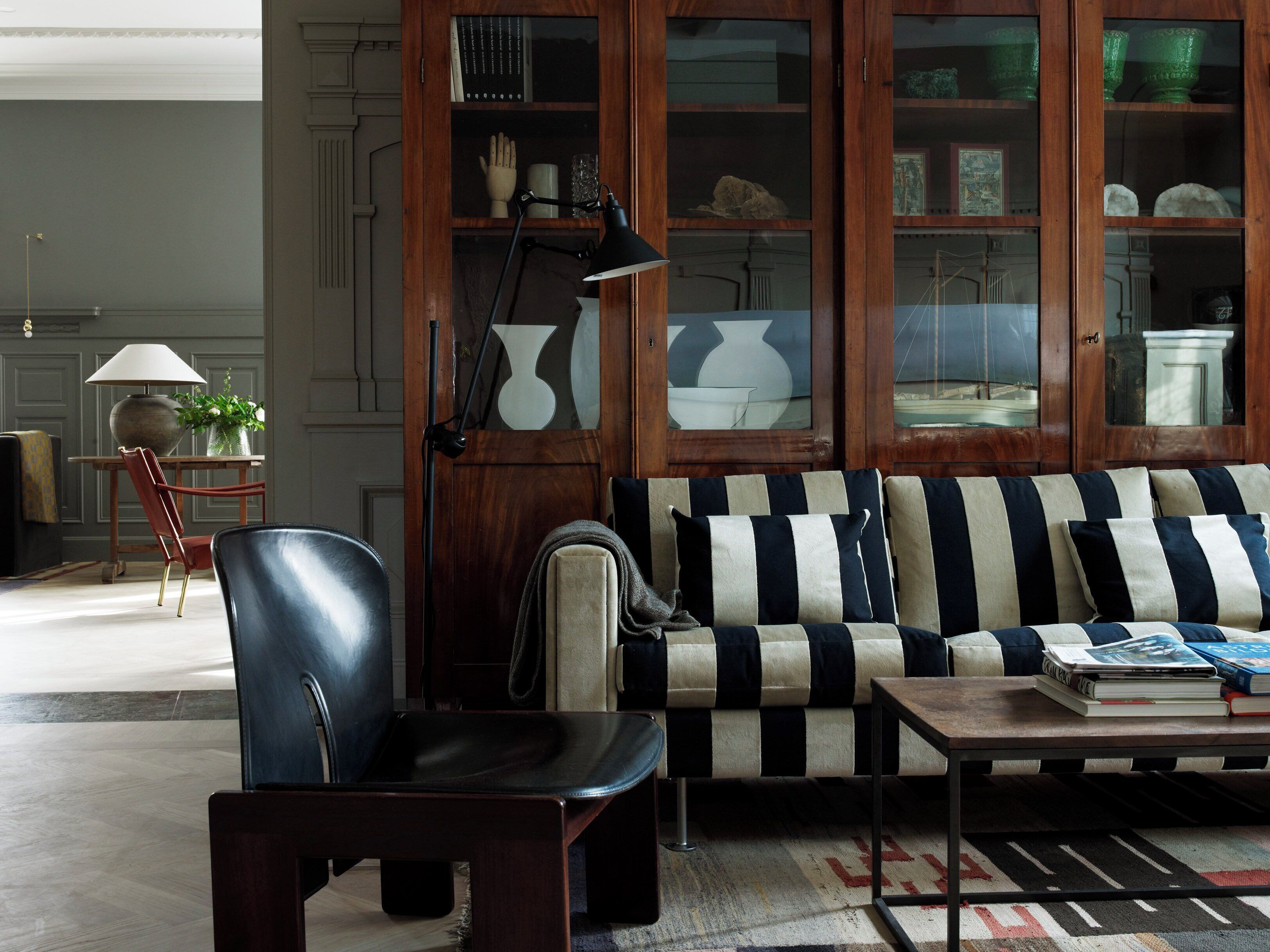 A living room with a sofa, a chair, a coffee table, and a cabinet with glass doors.