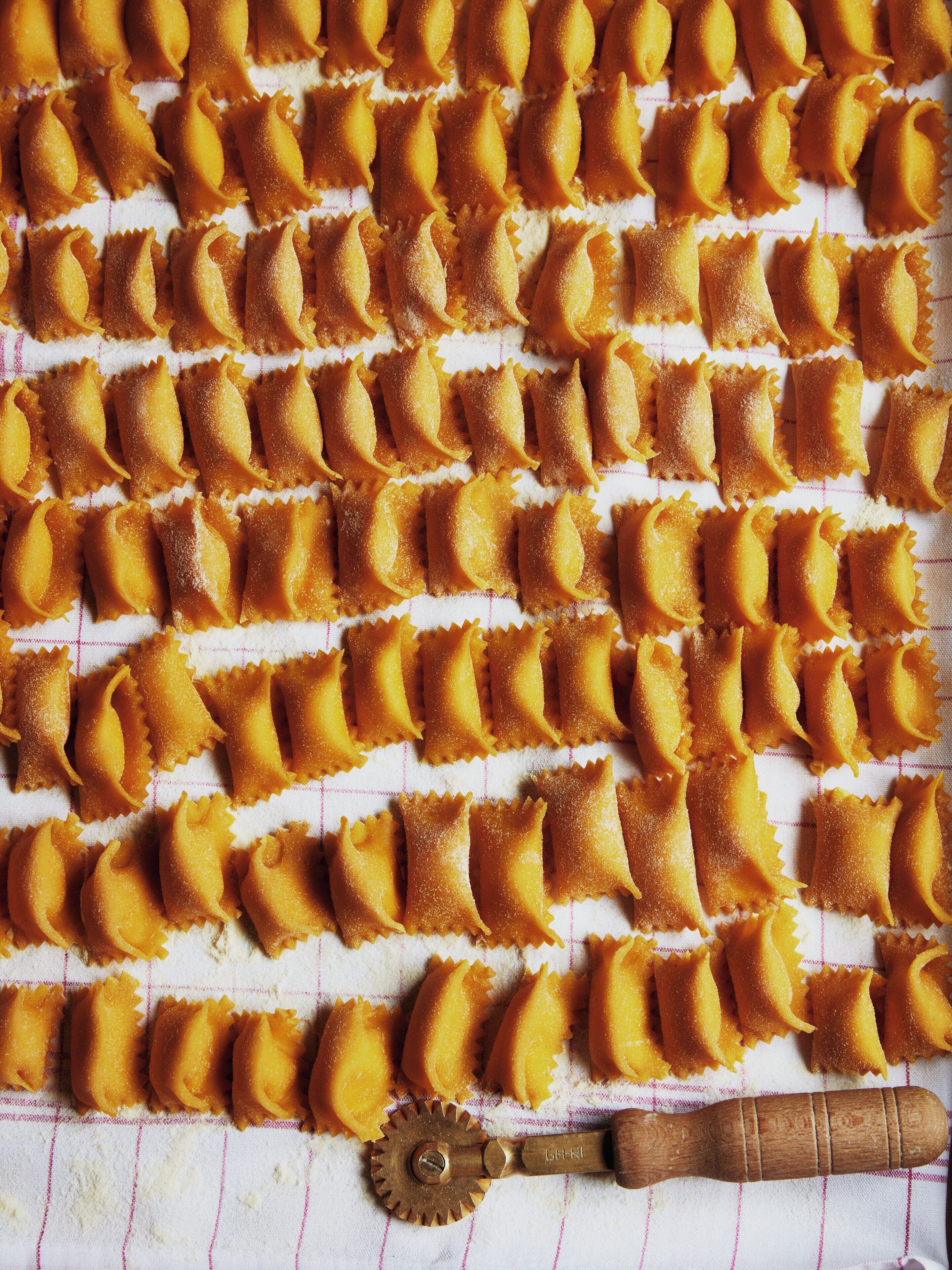 En bricka med ravioli, snyggt upplagda på en duk.