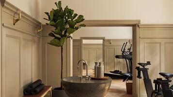 A spacious room with a large central sink, exercise equipment, and a bench.
