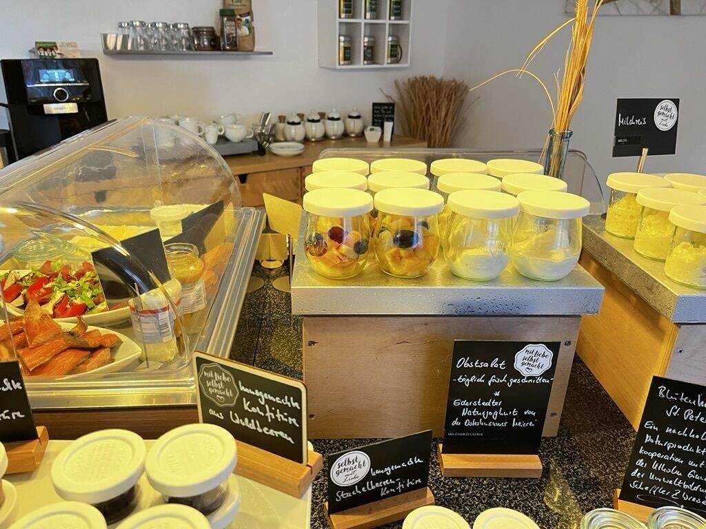 Una presentación de alimentos con varios frascos de conservas y una selección de sándwiches.