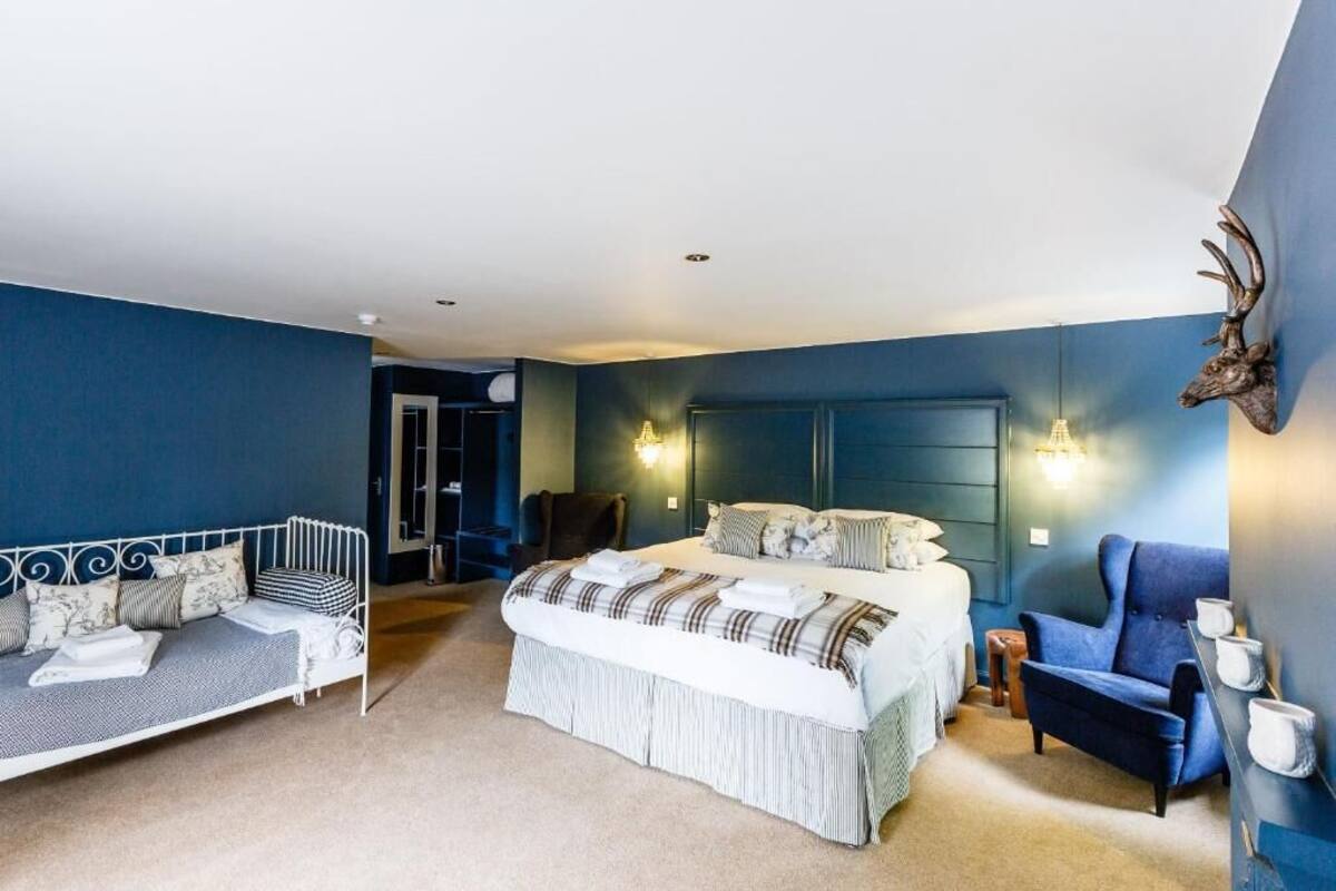 Ein Schlafzimmer mit Bett, einer Couch und einem Sessel.