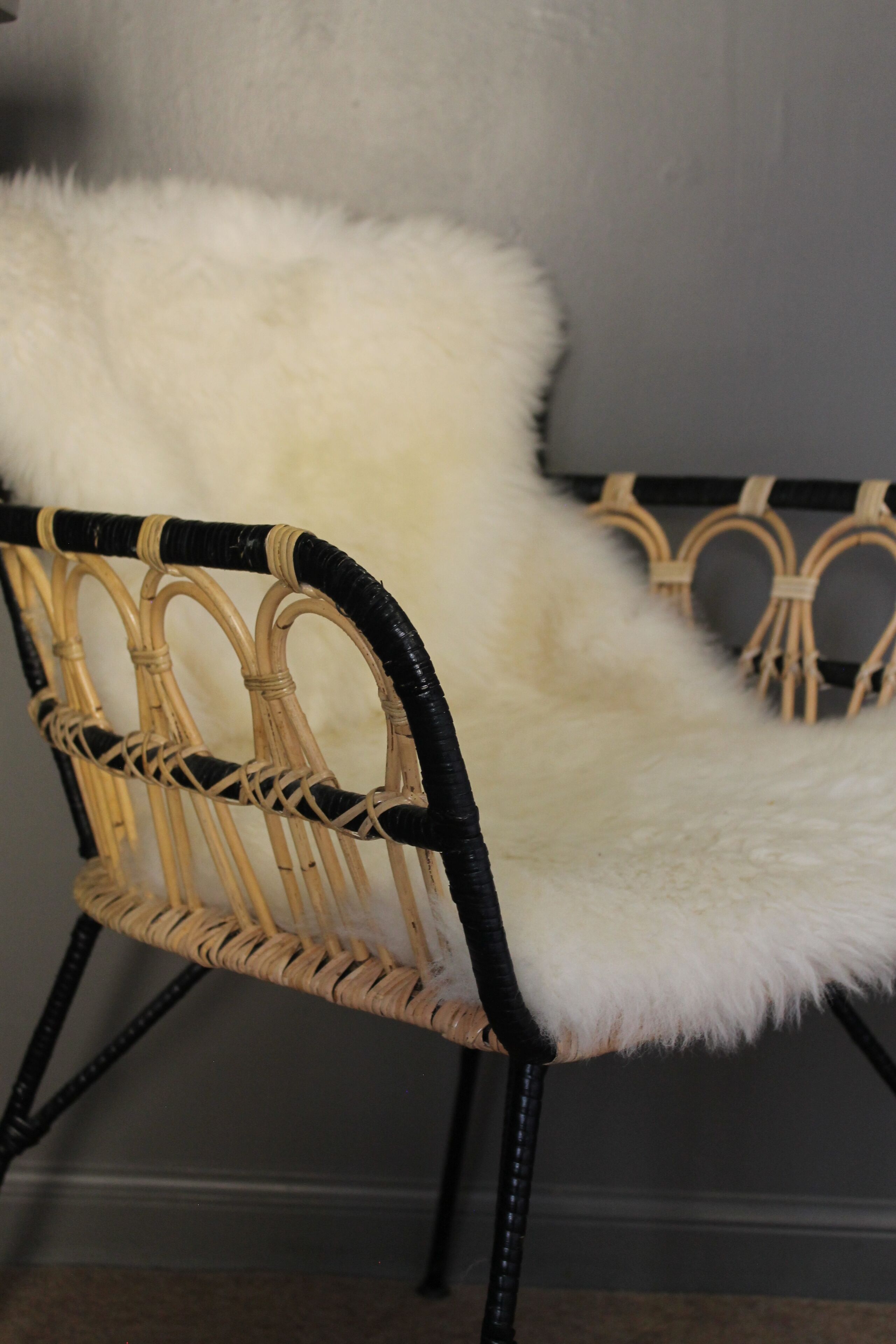 Una silla de mimbre con un cojín blanco mullido.
